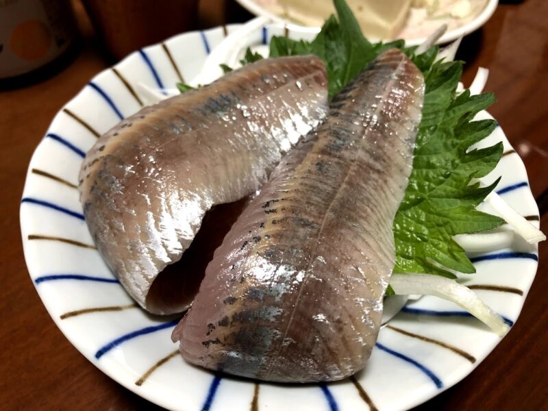 小皿に敷いた大葉の上に盛り付けたイワシの刺身
