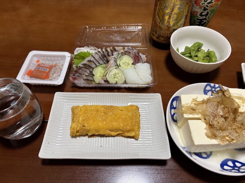 パック入りのイサキの刺身とだし巻き卵、冷奴などが並んだ晩酌の食卓