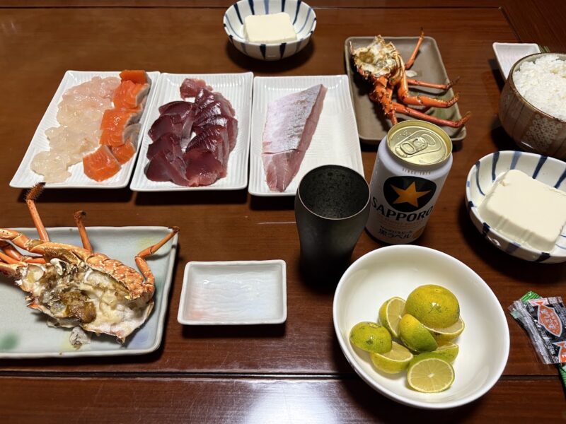 カツオやサーモン、白身魚の刺身の盛り合わせと伊勢海老の焼き物