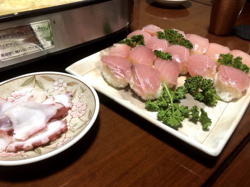 薄く切った魚をシャリにのせた握り寿司とタコの刺身