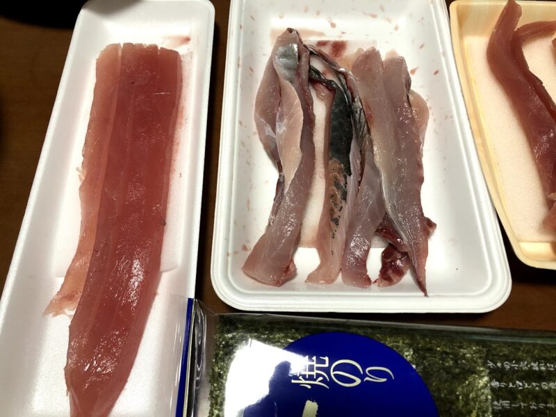 カツオの柵と青魚の刺身用切り身、海苔が並ぶ仕込み台