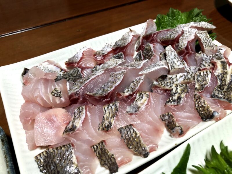 皮目に熱を入れた皮付き白身魚の刺身を白い皿に盛り付けた様子